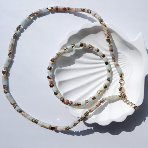 The Terra Oasis Beaded Necklace & Bracelet on plaster background