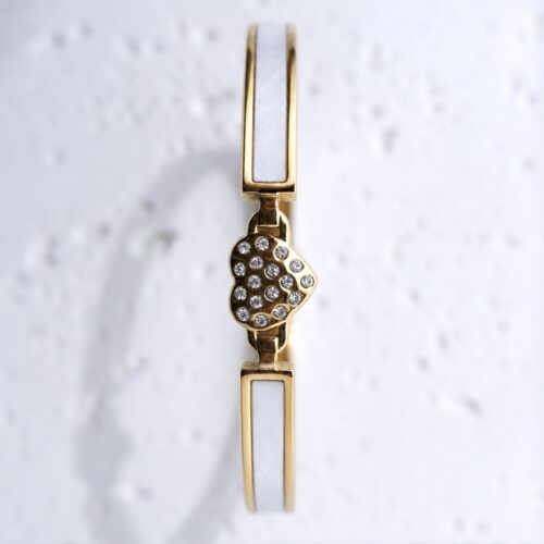 White Enamel Pavé Heart Gold Bangle on plaster background