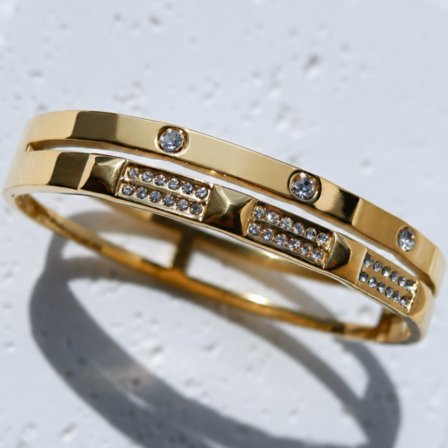Layered Gold Cuff with Crystal and Studs on a plaster background