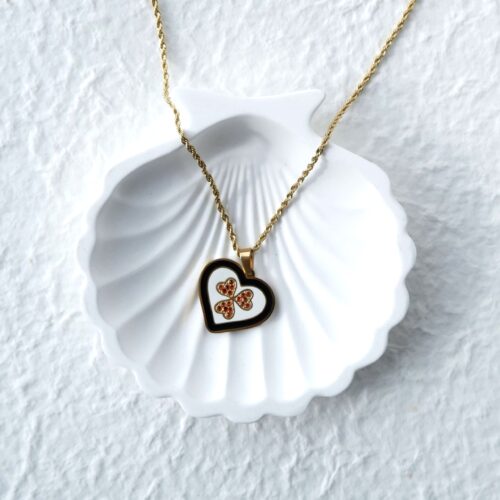 Gold Rope Chain Clover Heart Necklace on plaster background
