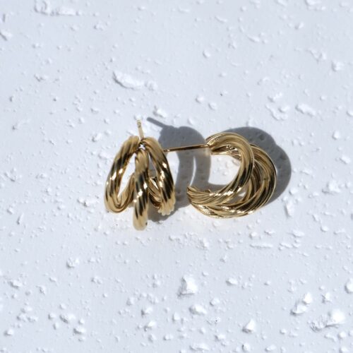 Chunky Triple Layered Gold Hoops on plaster background