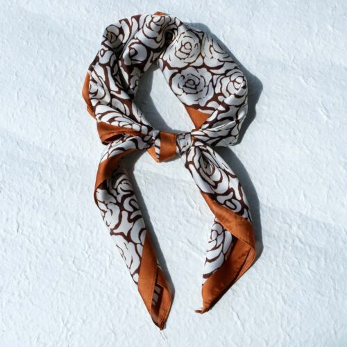 Caramel Border Rose Print Bandana on plaster background