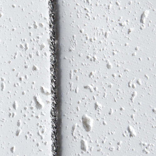 The silver Heritage Rope Chain Bracelet on a plaster background