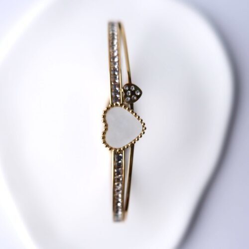 Gold Beaded Pearl Heart Double Band Bangle on plaster background