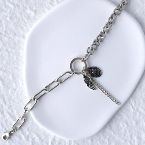 Antiqued Silver Mixed Chain Wing Bracelet on plaster background