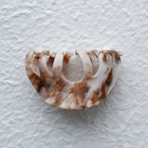 Caramel Marbled Hollow Arch Claw Clip on a plater background