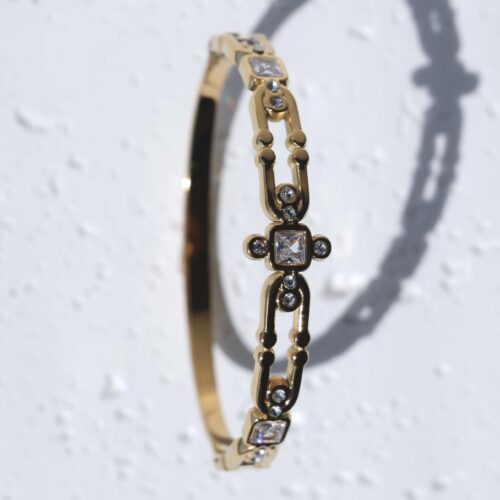 Gold Geometric Link Bangle with Square Crystals on plaster background