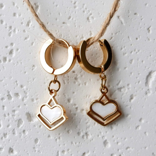 Geometric Framed Heart Dangle Huggie Earrings on a plaster background