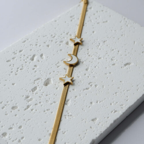 Gold Herringbone Star and Moon Bracelet on a plaster background